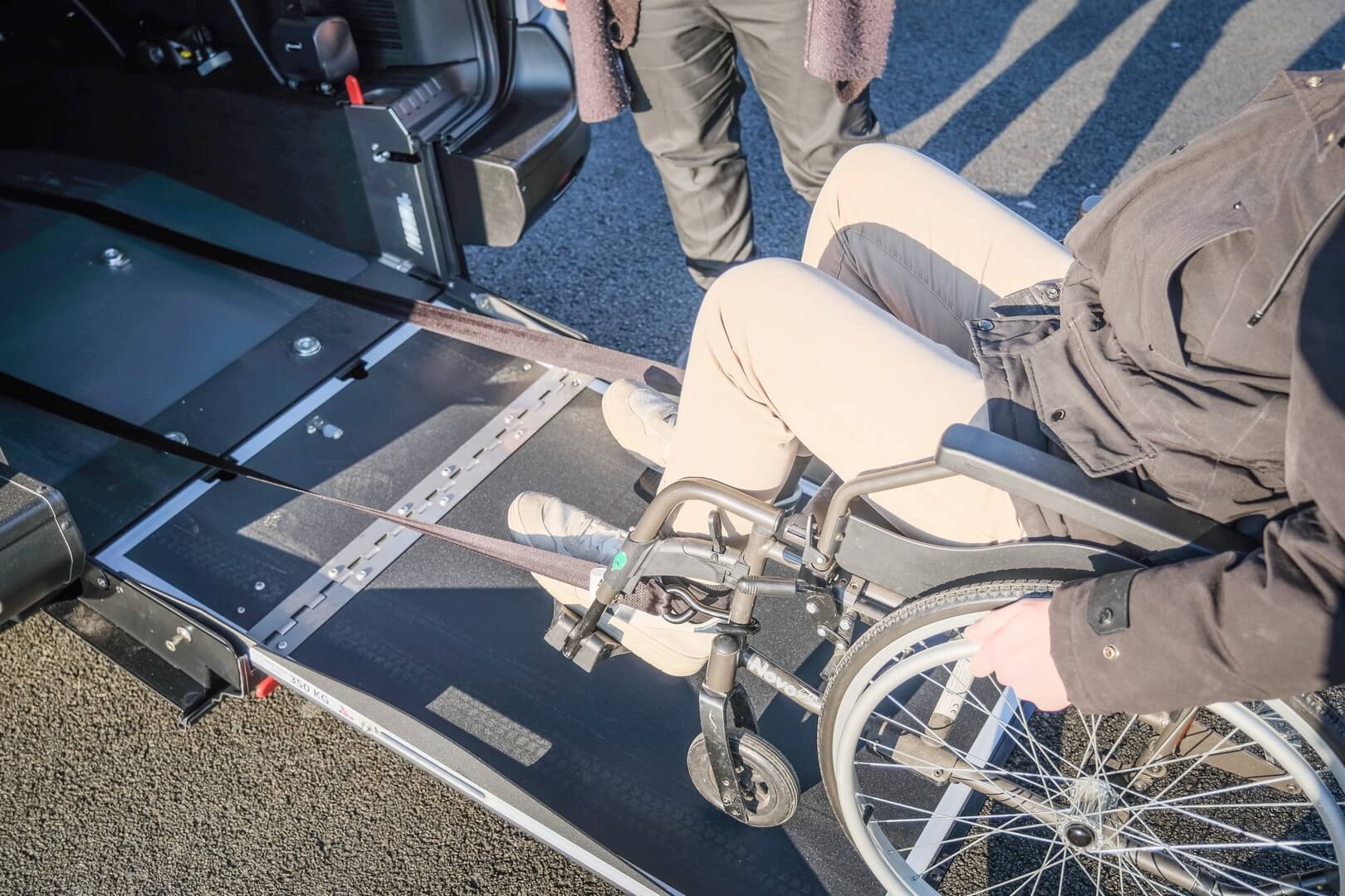 Les sangles avant rallongées à blocage électrique facilitent grandement l'arrimage du passager en fauteuil roulant