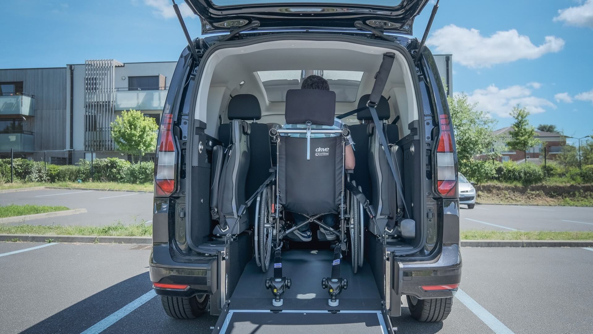 Votre proche en fauteuil roulant voyage confortablement et proche du rang 2 pour des trajets conviviaux dans le Volkswagen Caddy